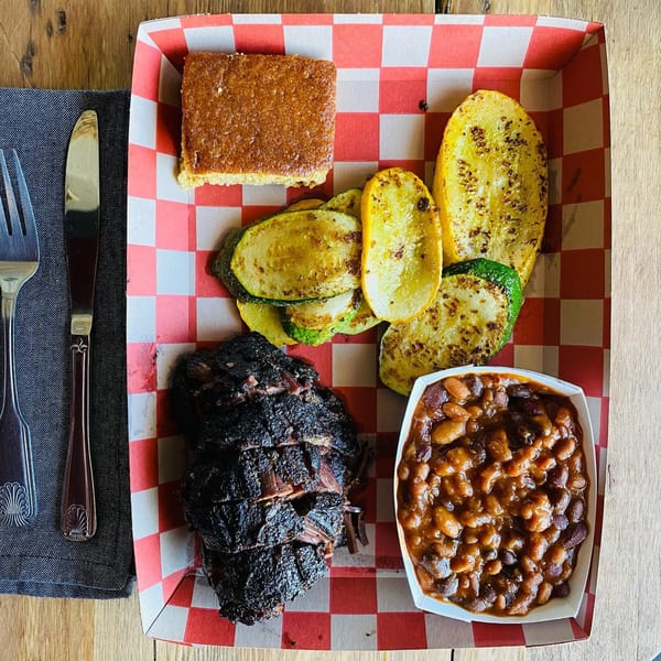 Wilson's Secret Sauce BBQ platter with brisket, baked beans, grilled zucchini, and cornbread.